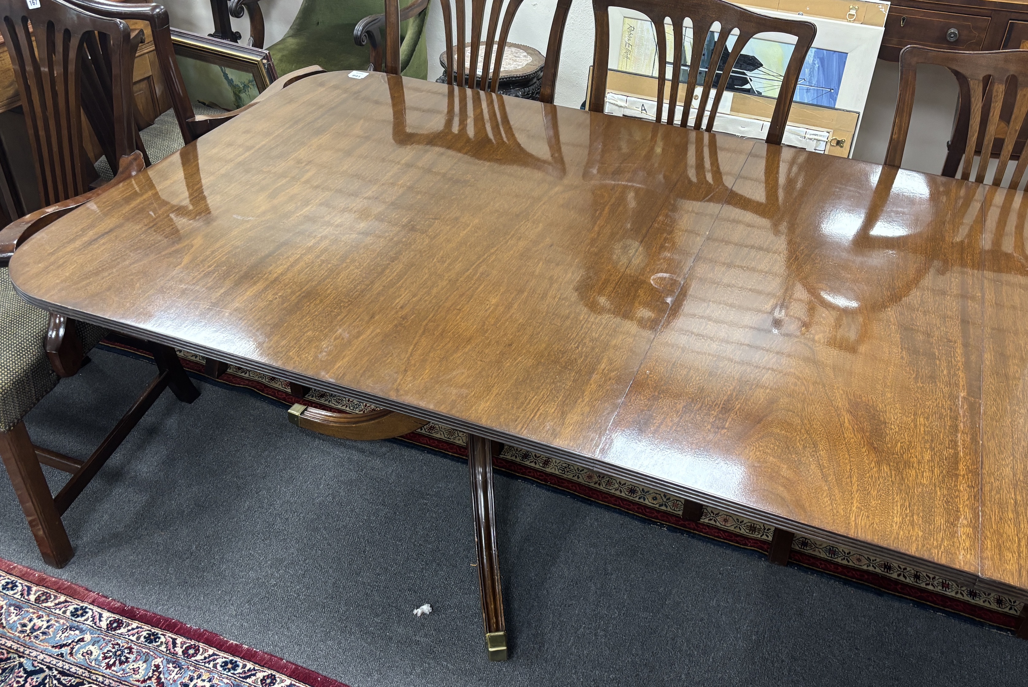 A reproduction George III style mahogany twin pillar extending dining table, 304cm extended, two spare leaves, depth 107cm, height 72cm